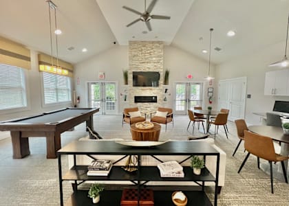A living room with a pool table and a fireplace.