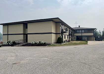 A large building with a parking lot in front.