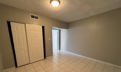 A room with a white tile floor and a white door.
