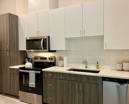 modern kitchen with white cabinets, stainless steel appliances, and quartz counters at Windsor Park Towers