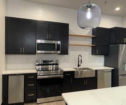 a kitchen with black cabinets and white countertops