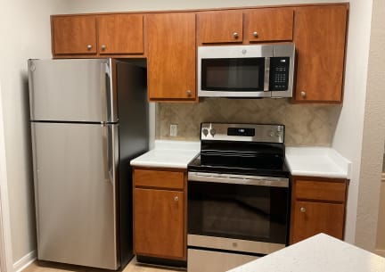 a kitchen with stainless steel appliances and wooden cabinets