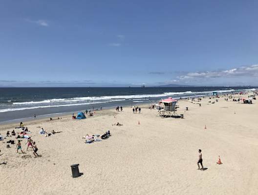 a crowded beach on a sunny day at the ocean