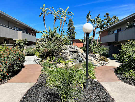 a courtyard with plants and a lamp post