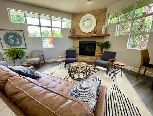 a living room with a brown couch and blue chairs