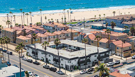 A beachfront town with a large body of water and a ship in the distance.