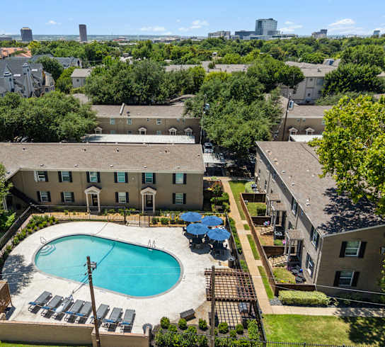 A large swimming pool surrounded by a fence and trees.