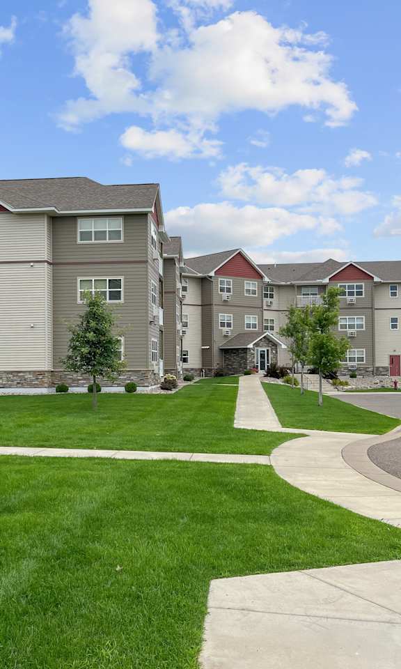 Apartment complex with a green lawn in front.