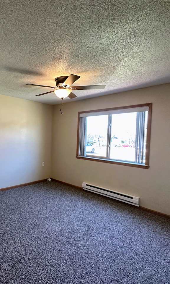 an empty room with a ceiling fan and a window