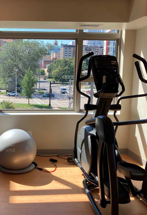 A room with exercise equipment and a view of the street outside.