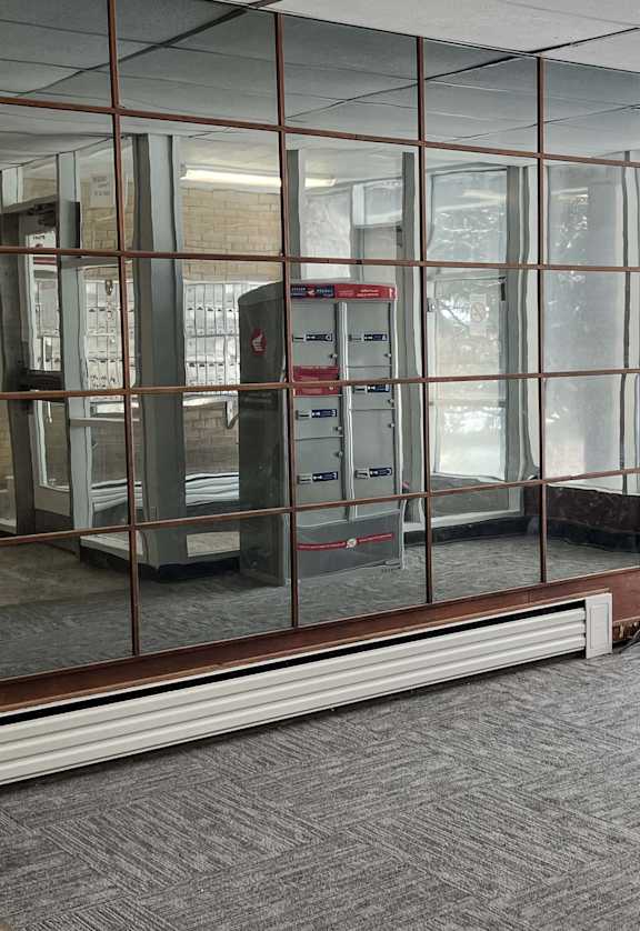 an empty room with glass walls and a vending machine