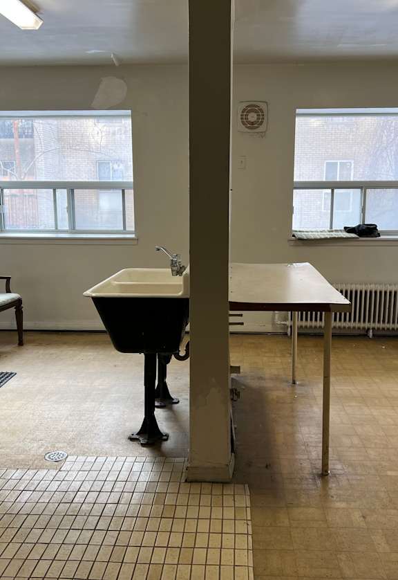 an empty laundry room with washing machines and a sink