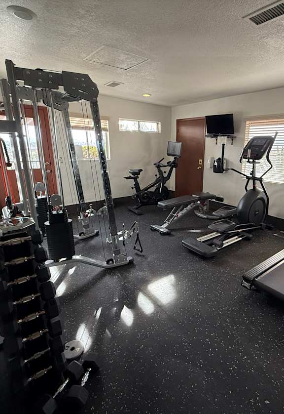 A spacious home gym with a variety of exercise equipment.