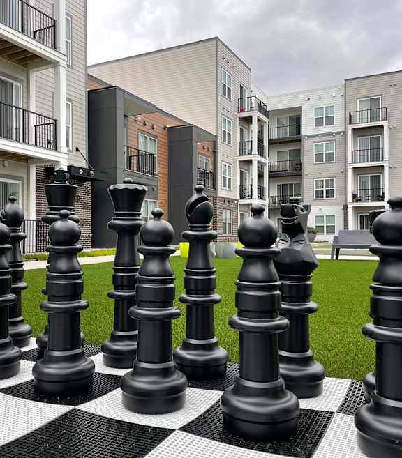 Giant chess pieces are set up on a green lawn at 42 Hundred On The Lake, St Francis, Wisconsin
