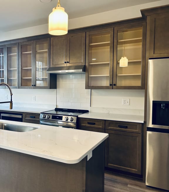 a kitchen with a large island and stainless steel appliances