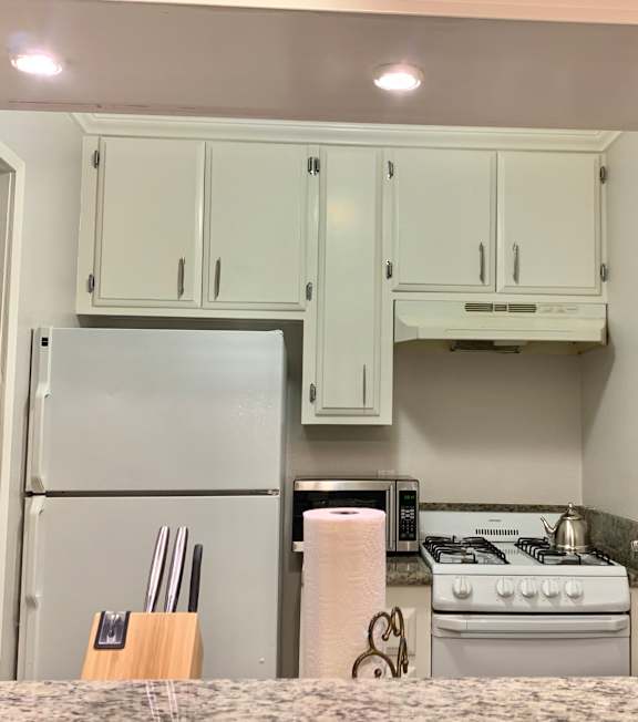 A well-lit, modern kitchen and living room with a dining area.
