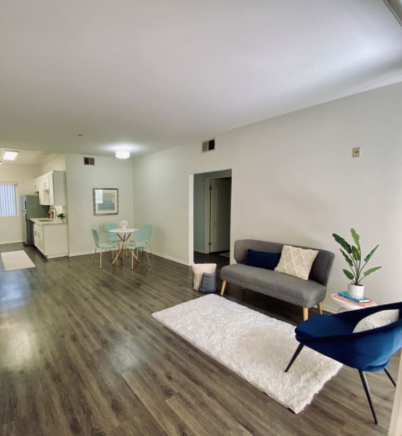 a seating area with two chairs and a coffee table on a concrete patio in front of a