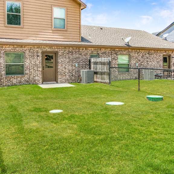 a backyard with a frisbee court and a house