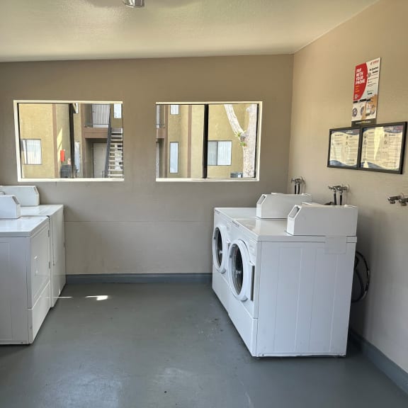a laundry room with two washers and two dryers