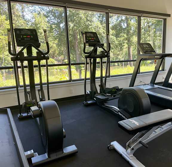 a gym with a lot of exercise equipment on the floor at Commons on the Tualatin River, Tualatin, OR