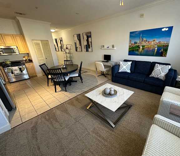 A living room with a blue couch and a coffee table in the center.