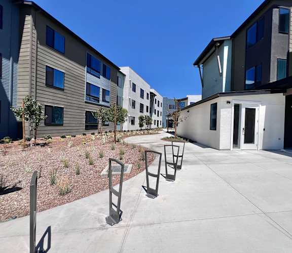 A sunny day at a modern apartment complex with a clear blue sky.
