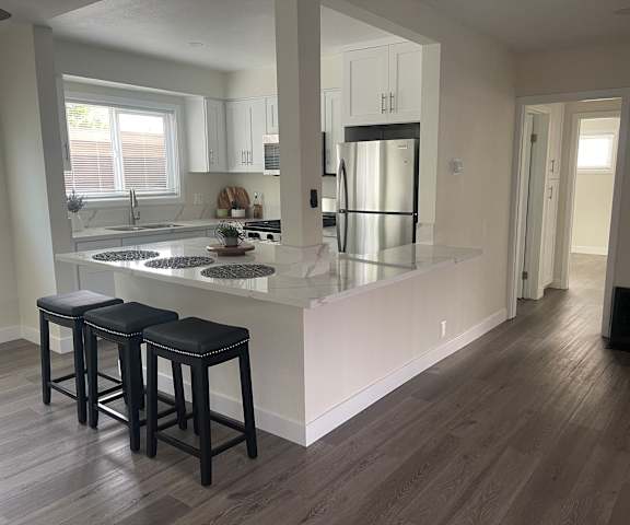 a kitchen with an island and three stools in it