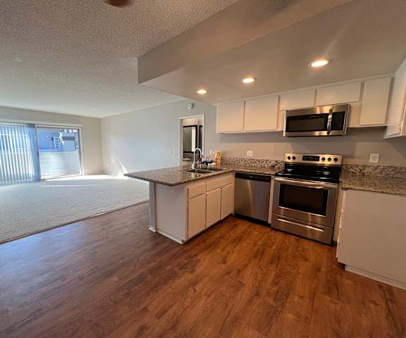 an empty kitchen with stainless steel appliances and a counter top