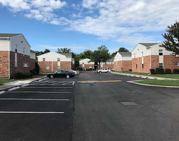 an empty parking lot in a neighborhood with brick buildings