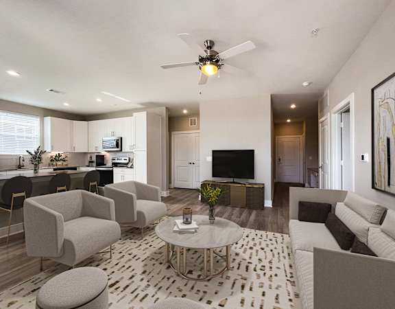 A modern living room with a white sofa, grey armchairs, and a patterned rug.