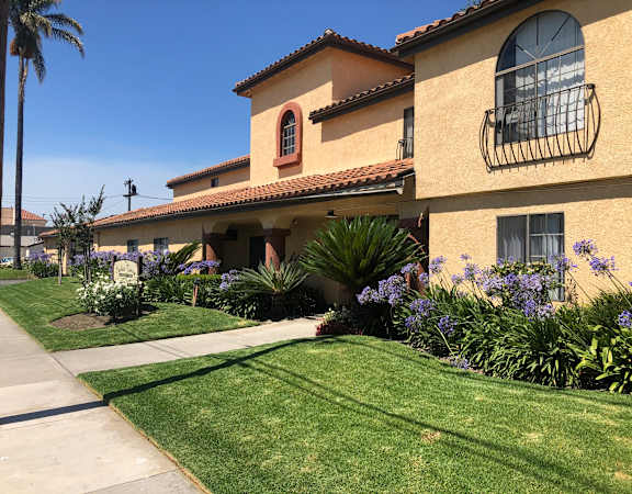 a house with a lawn and flowers in front of it