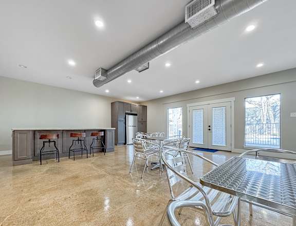A spacious dining area with a bar and chairs.