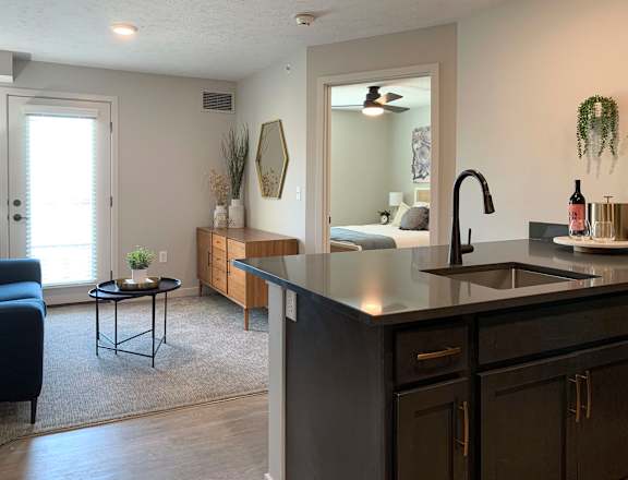 a kitchen with an island and a living room in the background