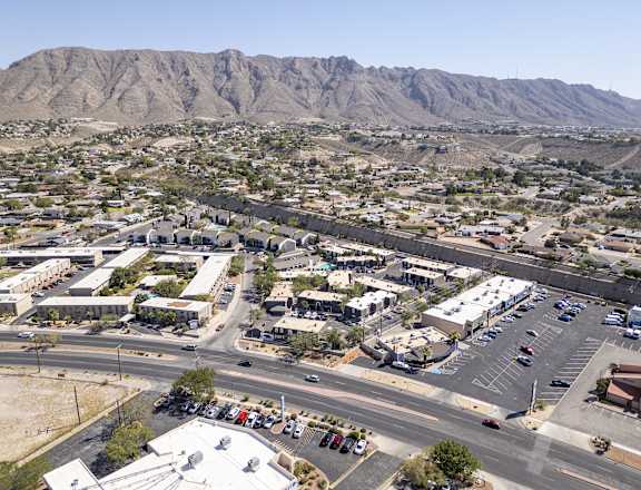A parking lot with cars and a mountain in the background.
