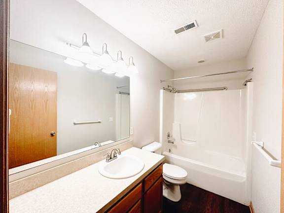 A bathroom with a sink, toilet, and bathtub.