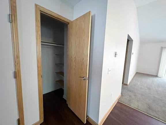 A wooden door with a shelf underneath it is open.