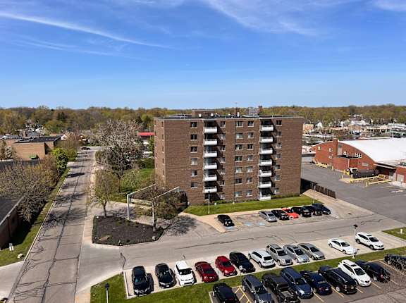 an aerial view of a parking lot in front of a brick building