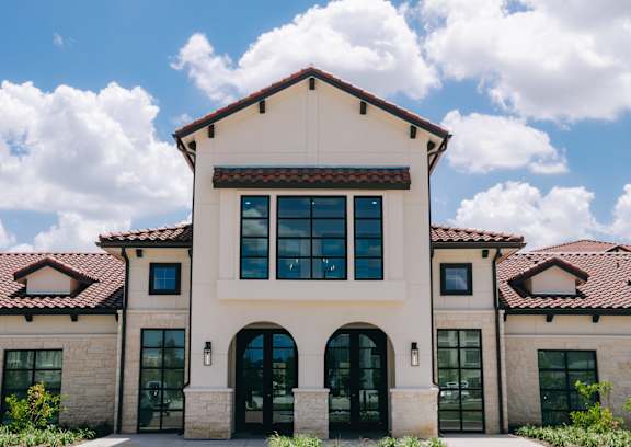 A large house with a red tile roof and a stone facade. at Northwoods, Texas, 77388