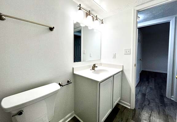 A white bathroom with a white sink and a white bathtub.
