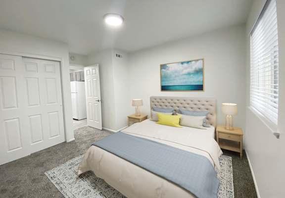 Carpeted bedroom with double sliding door closet on left and large window on right. Staged with queen-size bed and side tables.at Summit, Pocatello, 83201