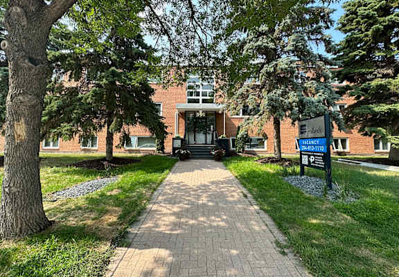 a brick building with trees in front of it