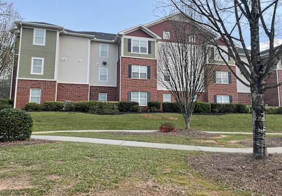an apartment building with a sidewalk in front of it