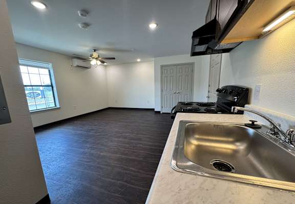 A kitchen with a sink and a stove top oven.