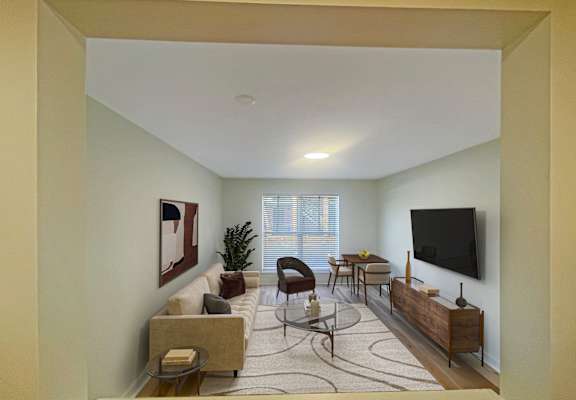 A living room with a couch, chairs, and a television.