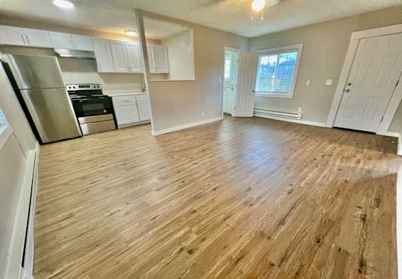 A kitchen with white cabinets and a stainless steel refrigerator.