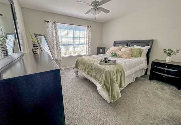 a bedroom with a bed and a ceiling fan