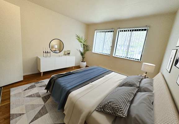 a bedroom with a bed and a dresser and windows at The Lodge Apartments