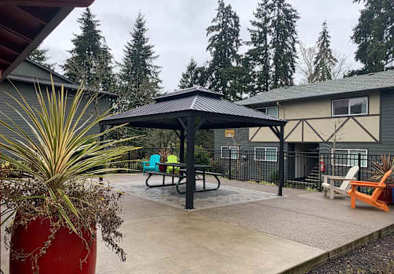 A red pot with a plant in it sits in front of a playground.