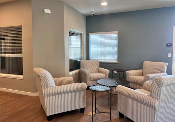 A living room with striped chairs and a table.