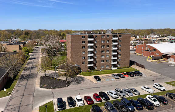 an aerial view of a parking lot in front of a brick building